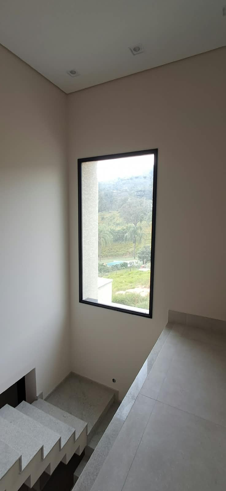 Esquadria preta com vidro incolor na escada da residência