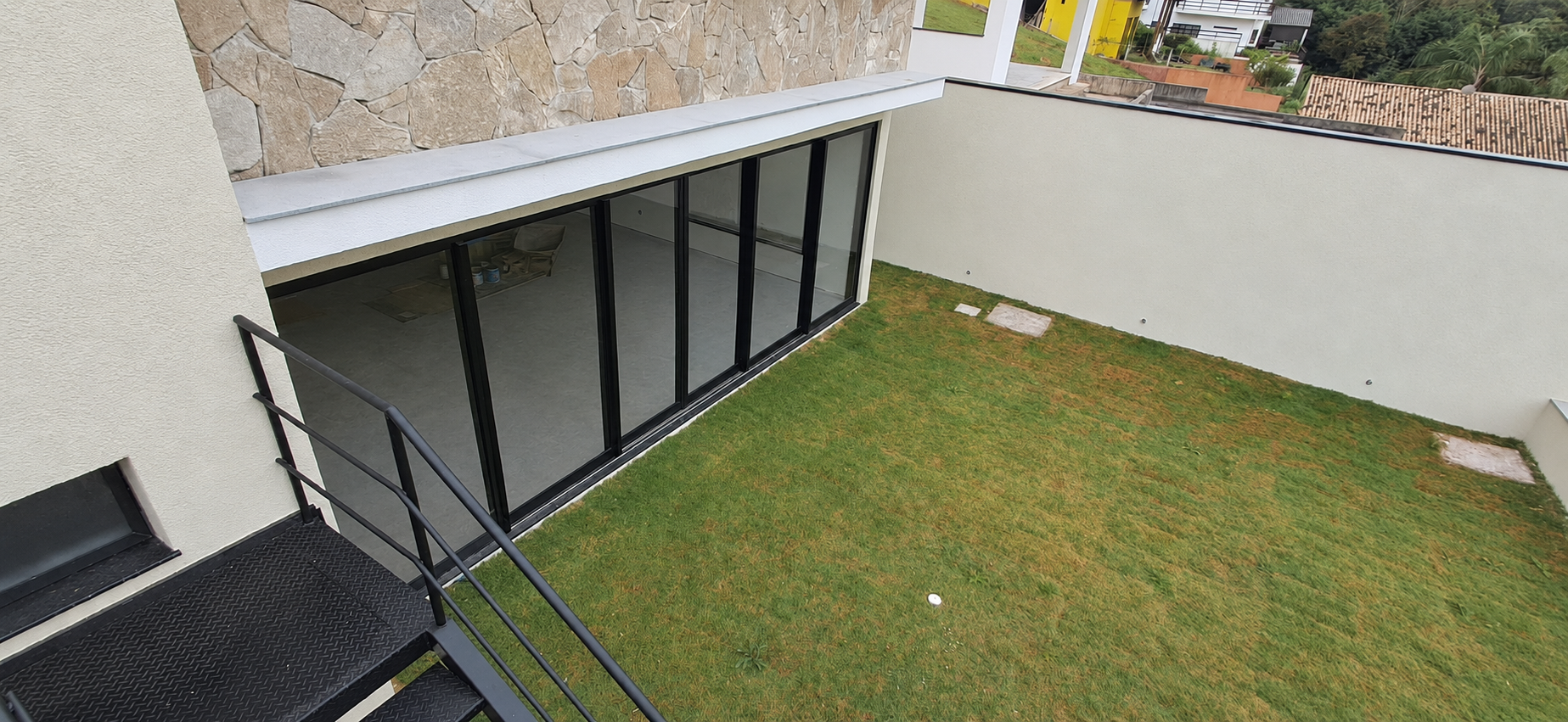 Conjunto de portas de correr pretas voltado para o jardim