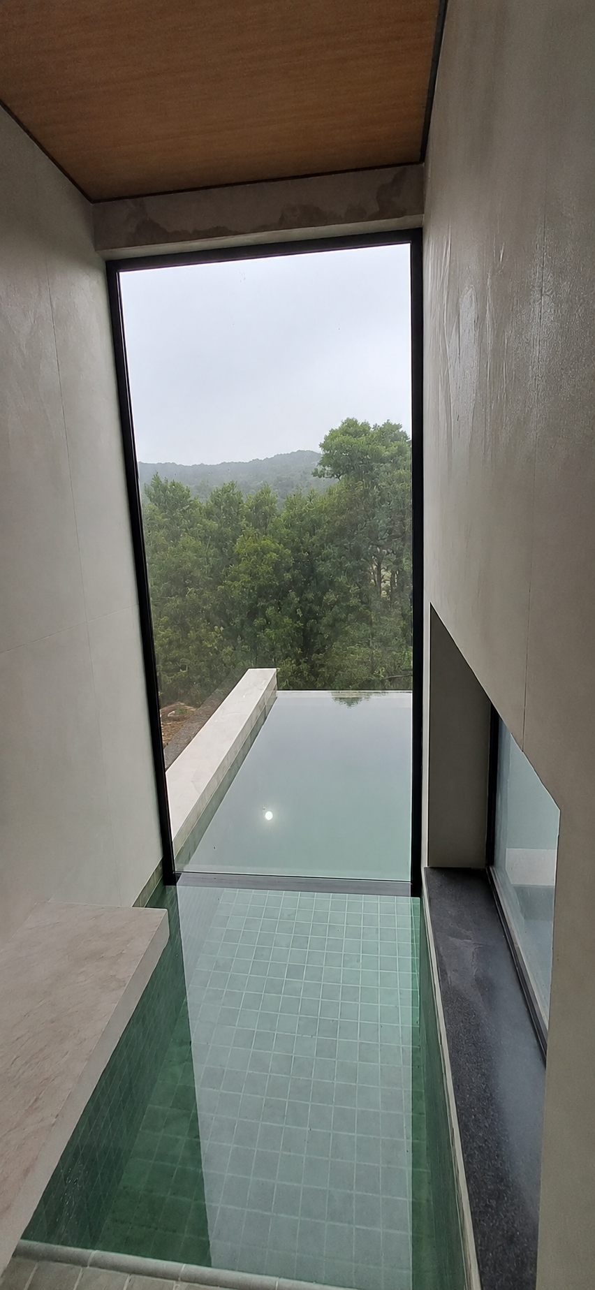 Fechamento em vidro com perfis pretos junto à área da piscina