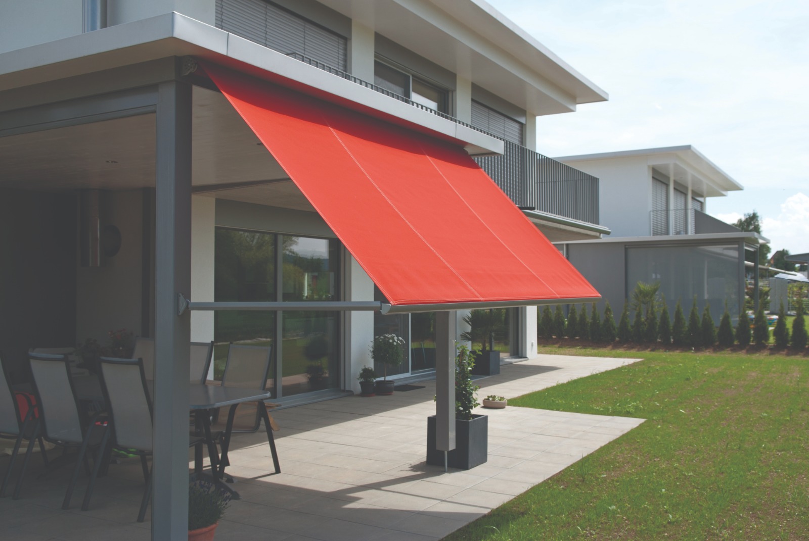 Toldo articulado vermelho em área externa residencial